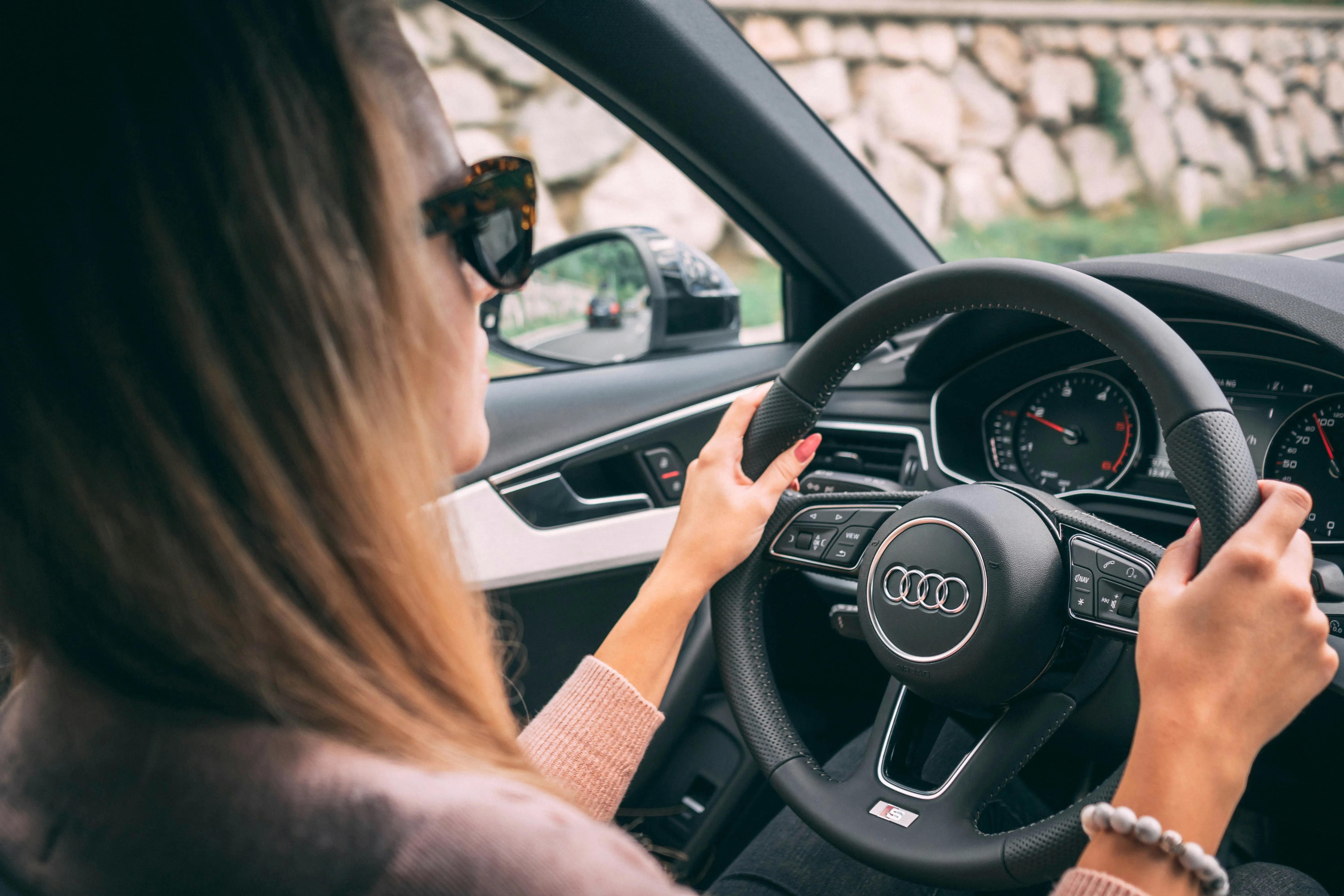 Junge Fahrschülerin konzentriert am Audi-Lenkrad